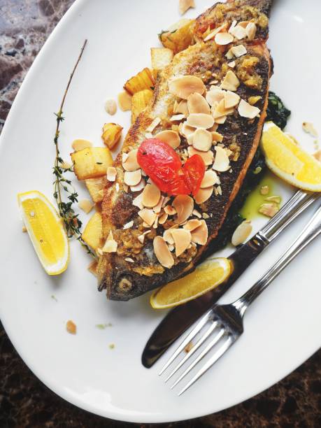Baked fish carp with lemon greens and potatoes on a plate Copy space