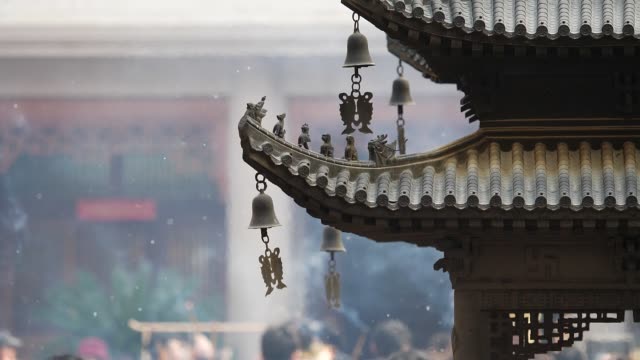 Immortal and beasts on the eaves of the building in Shanghai Jingan temple, Imperial yellow roof decorations, Wind bells under eaves sway with the wind, high speed video, slow motion.