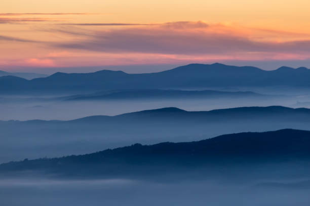 istock Beautifully colored sky at dusk, with mountains layers and mist between them 1134607537