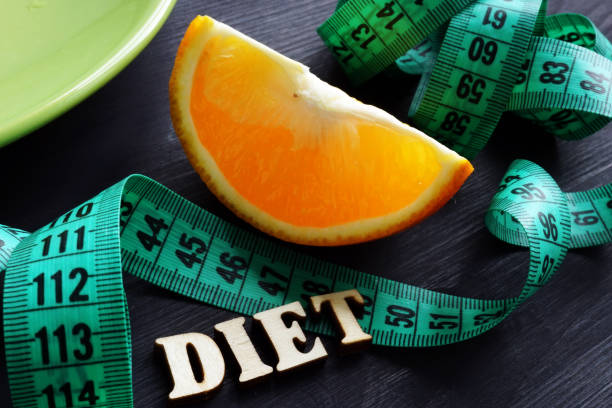 istock Weight loss concept. Plate and word diet on a desk. 1134608459
