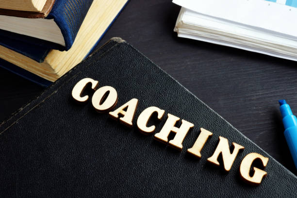 istock Coaching from wooden letters on a book. Mentoring. 1134608479