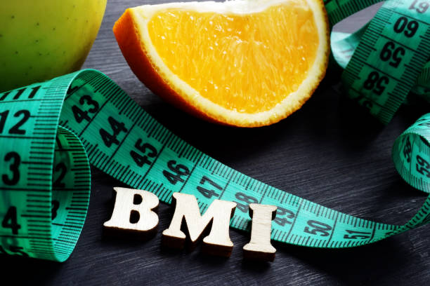 istock Letters BMI body mass index with measuring tape and orange. 1134608632