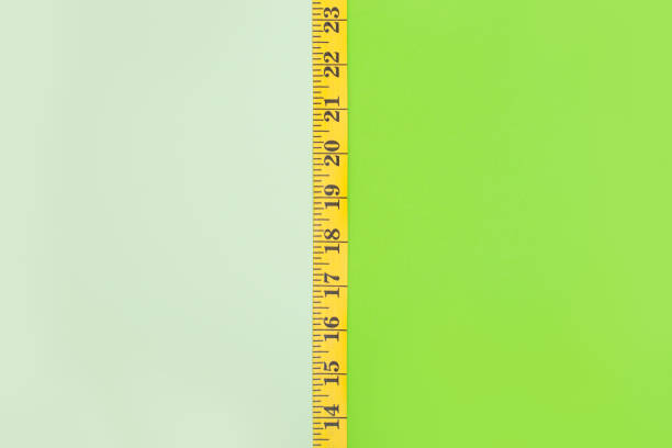 istock Green background with empty space devided into two parts with tape measure 1134609934