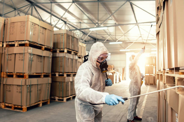 istock Exterminators in warehouse spraying pesticides with sprayer 1134613205