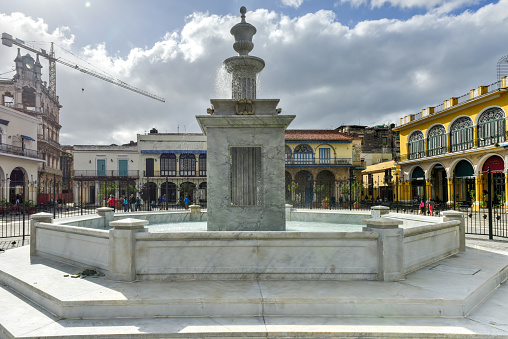 Buildings and fountain surrounding Plaza Vieja (Old Square) in Old Havana, Cuba.