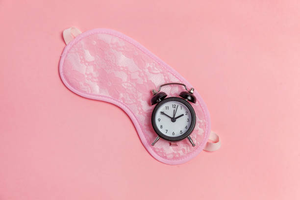 istock Sleeping mask and alarm clock on pink background 1134623872