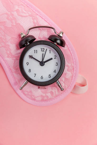 istock Sleeping mask and alarm clock on pink background 1134623994