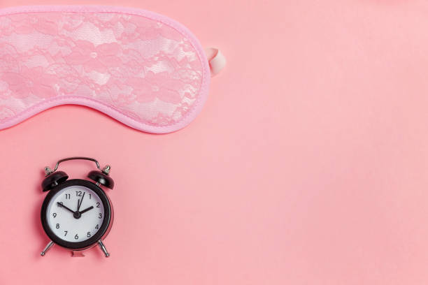 istock Sleeping mask and alarm clock on pink background 1134626241