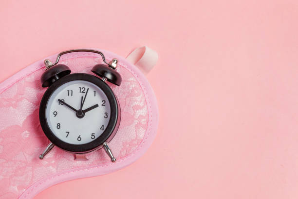 istock Sleeping mask and alarm clock on pink background 1134626293