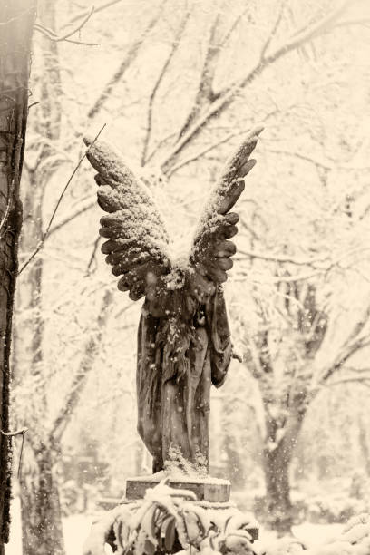istock Snowy Antique Angel Statue in a German Cemetery 1134629848