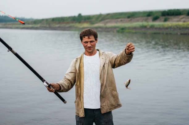 istock A man caught a fish. Fisherman caught a small fish 1134630846