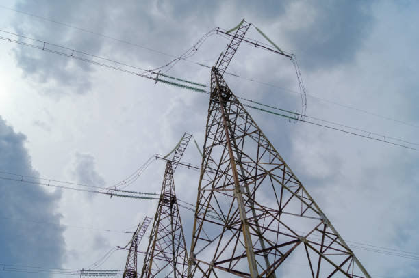 istock Power transmission towers on a background of cloudy sky with gray clouds 1134630976