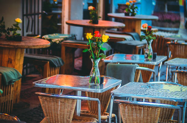 a small cafe, flowers in vases on the tables, wicker furniture