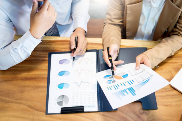 istock Midsection Of Colleagues Working Over Graph In Office 1134633509
