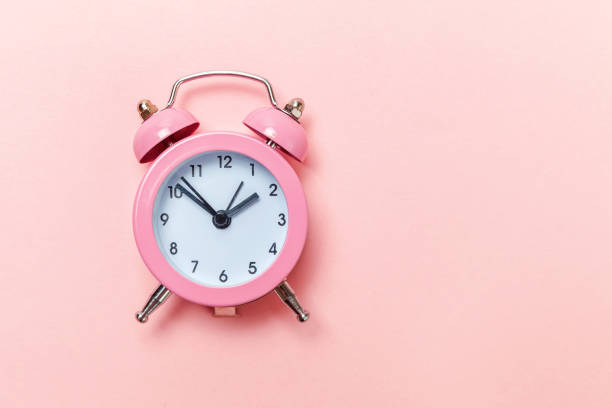 istock Vintage alarm clock Isolated on pink pastel background 1134635194