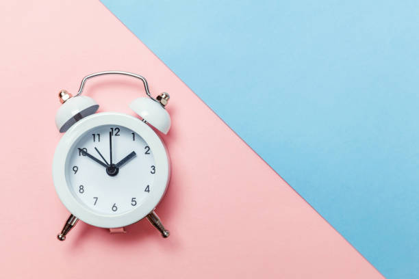 istock Vintage alarm clock Isolated on blue and pink pastel background 1134635485