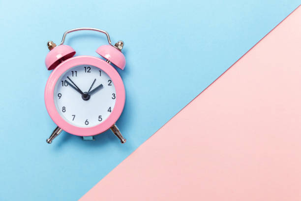 istock Vintage alarm clock Isolated on blue and pink pastel background 1134635592