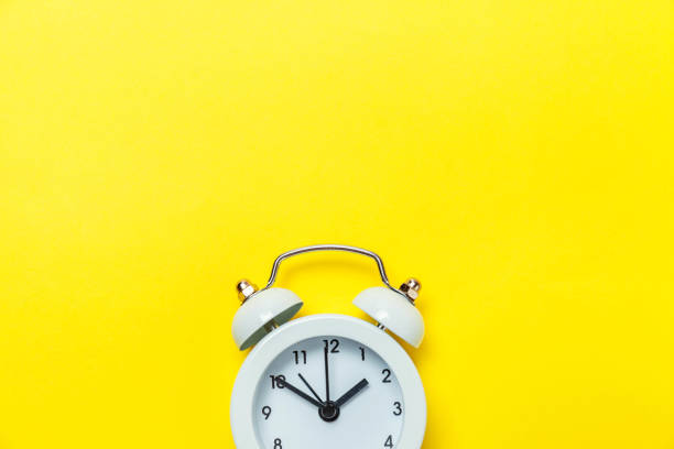 Vintage alarm clock Isolated on yellow background