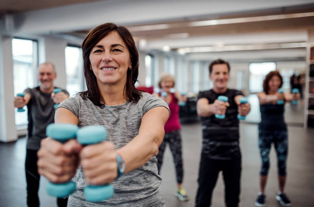 istock Group of cheerful seniors in gym doing exercise with dumbbells. 1134638645