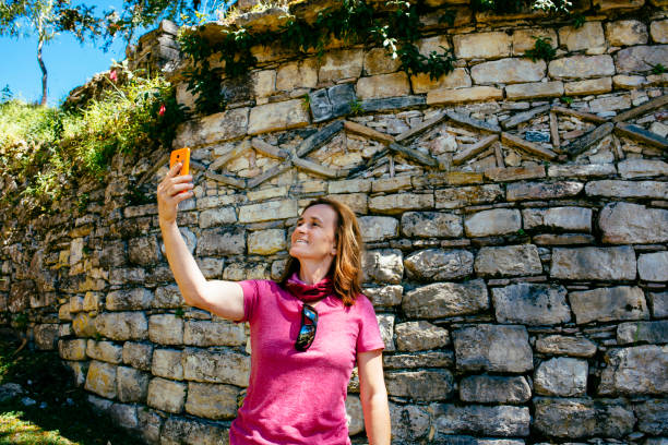 A female tourist take selfies in front of pre-inca walls /Kuelap / Chachapoyas/ Peru/ south america stock photo