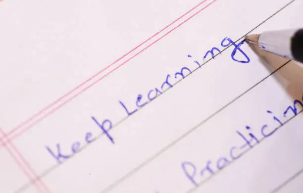 The word "Keep Learning" is being writing down on the notebook will blue  ball-pen to represent and encourage user to learn something regularly.