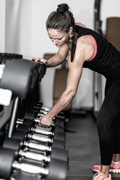 istock Woman Lifting Dumbbell From Rack In Gym 1134651106