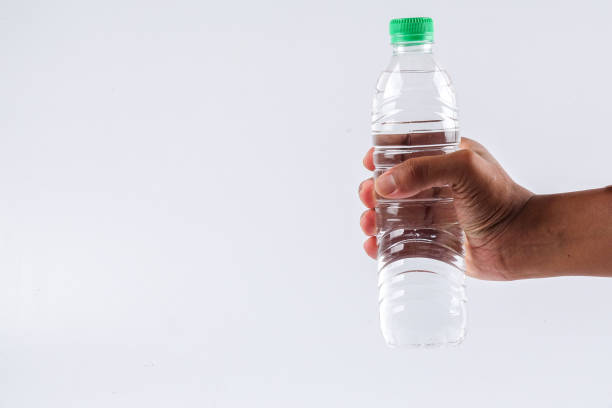 istock Cropped Hand Holding Water Bottle Against White Background 1134652339