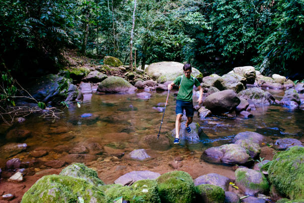 Young boy is crossing an clear river in the tropical rain forest  near Tarapoto/ San Martin/ north peru/ South America stock photo