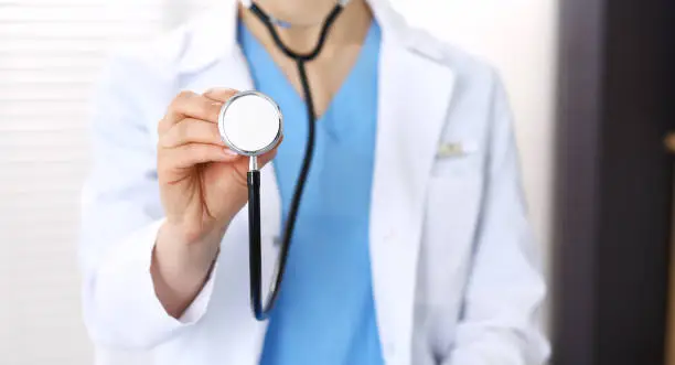 Doctor woman holds stethoscope head, close-up. Physician ready to examine and help patient. Helping and insurance in health care, best treatment and medicine concept.