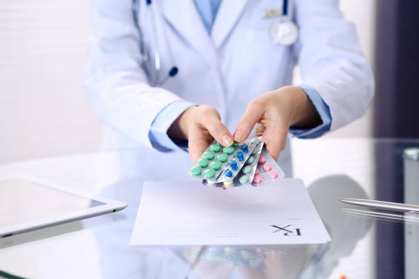 istock Unknown doctor hands holding pack of different tablet blisters closeup. Life save service, legal drug store, prescribe medication, disease healing concept 1134655347