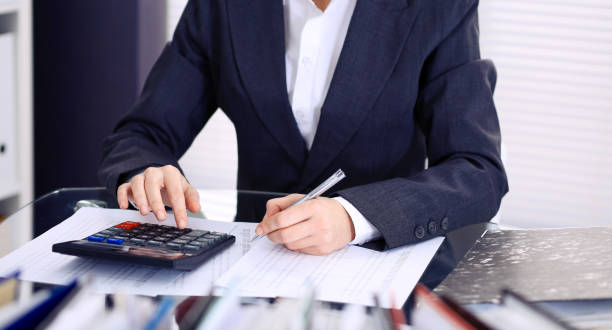 istock Unknown bookkeeper woman or financial inspector  making report, calculating or checking balance, close-up. Business portrait. Audit or tax concepts 1134655358