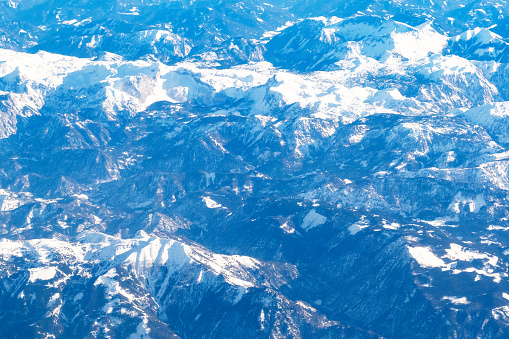 aerial view of tops of Alps mountain from airplane in flight in Februay