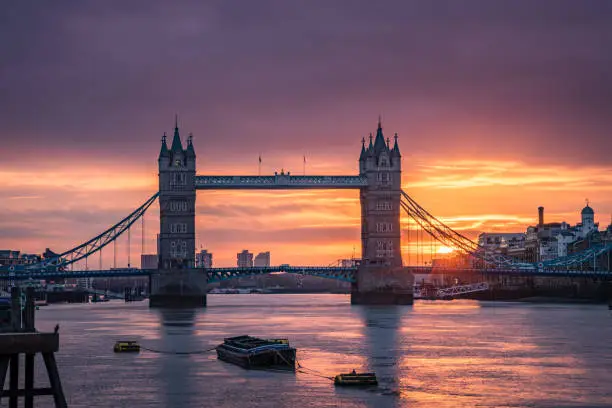 Beautiful vivid sunrise above Tower bridge and Thames river in London city as photographed from London Bridge with long lens during the early morning hours. Shot on Canon EOS R full frame system.