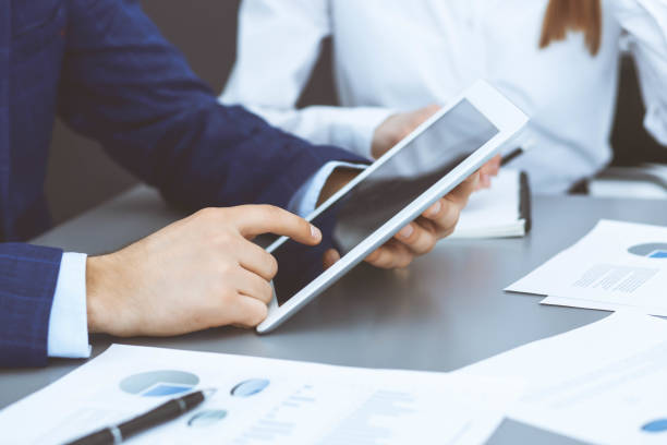 istock Businessman using touchpad at meeting, closeup of hands 1134660143