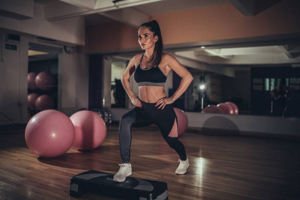 mulher nova que faz lunges na ginástica - single step - fotografias e filmes do acervo