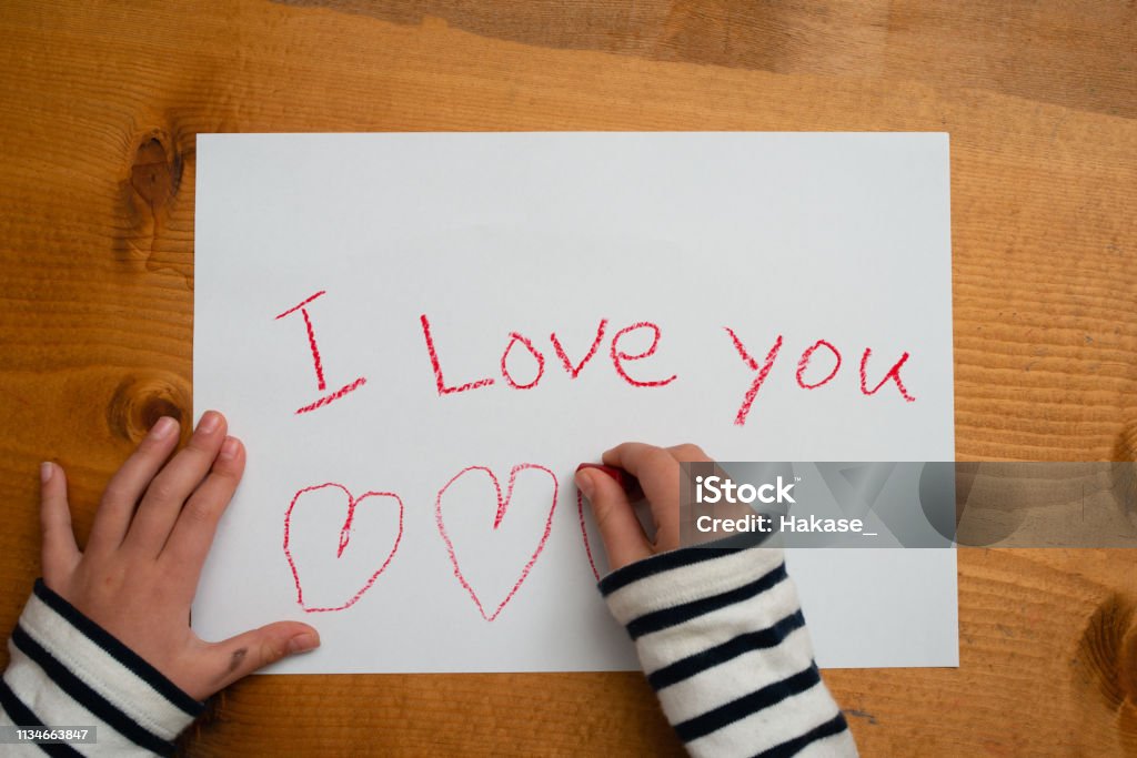 Child writes i love you on paper Letter - Document Stock Photo