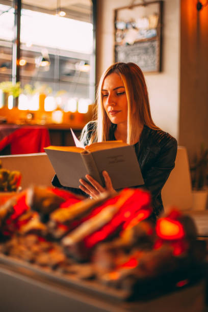 istock Young woman Reading Books by the Fireplace 1134664664