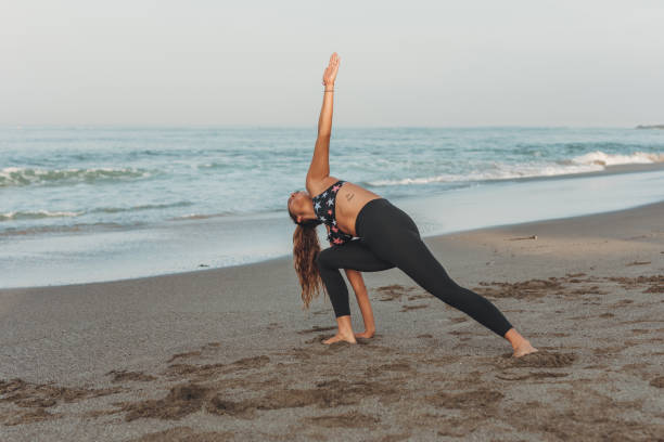 istock Beautiful Young Woman Stretching At The Beach 1134665233