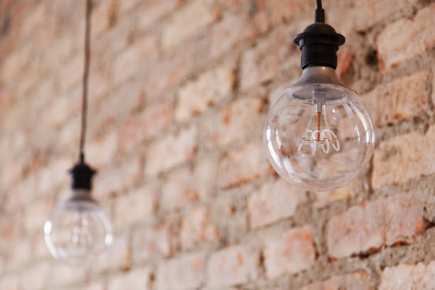 istock Decorative antique edison style light bulbs against brick wall background 1134669863