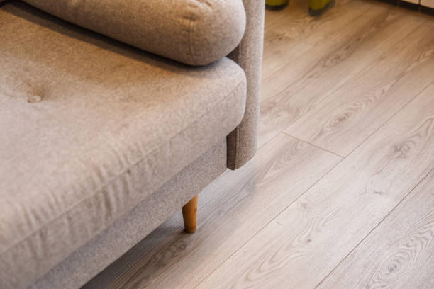 istock Grey sofa with wooden legs on lamonate floor 1134669926