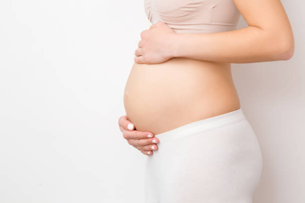 woman hands touching naked belly isolated on gray background. emotional loving pregnancy time - 20 weeks. baby expectation. love, happiness and safety concept. side view. empty place for text. - abdomen gynecological examination women loving imagens e fotografias de stock