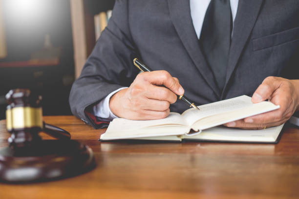 istock Midsection Of Lawyer Reading Book While Sitting In Office 1134685283
