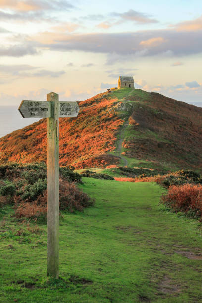 Footpath and Signage on the Rame Head Penisula, leading to Ruined Chapel, South East Cornwall. Footpath and Signage catching the early morning light, on the Rame Head Penisula, leading to Ruined Chapel, South East Cornwall. rame stock pictures, royalty-free photos & images