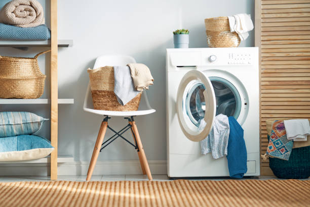 laundry room with a washing machine Interior of a real laundry room with a washing machine at home laundry stock pictures, royalty-free photos & images