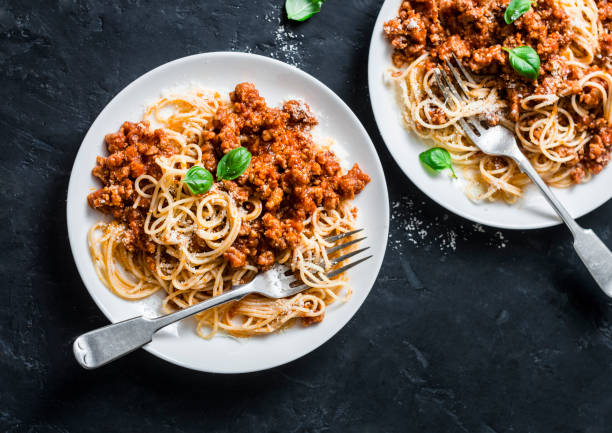 purée de haricots, champignons sauce bolognaise végétarienne avec spaghetti sur fond sombre, vue de dessus - mash bean photos et images de collection