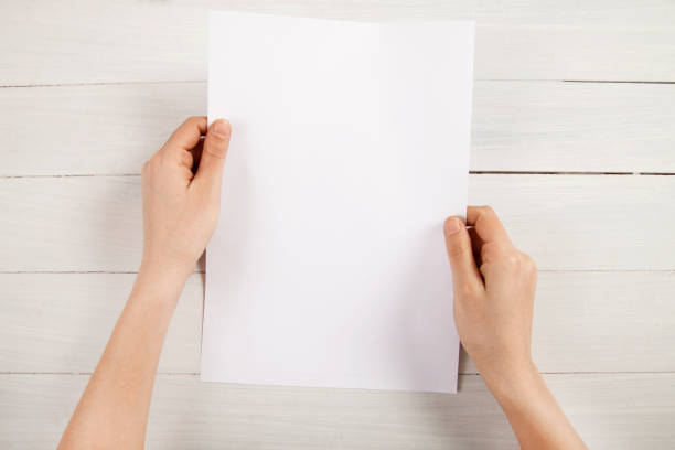 Person holding white empty paper stock photo