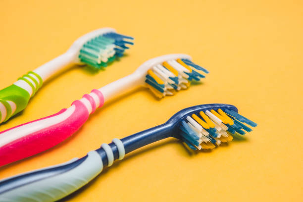 mehrfarbige zahnbürsten. textfreiraum. - toothbrush pink turquoise blue stock-fotos und bilder