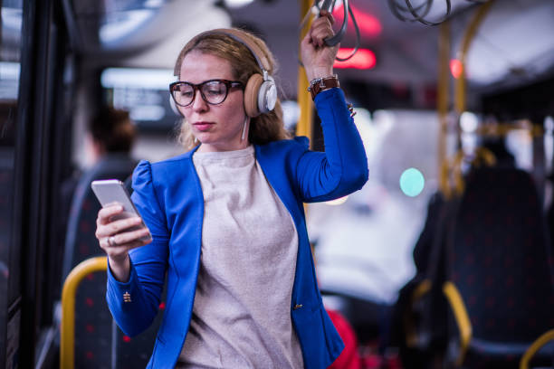 Business woman listening music in public transport. stock photo