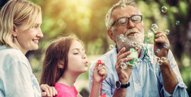 istock Happy family blows soap bubbles together while going vacation on weekend in the garden park in summer. Kid education and family activities concept. 1134706207