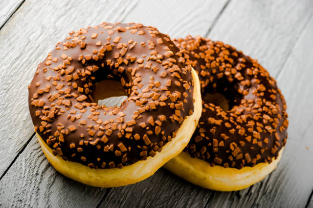 istock Tasty donuts on wooden table 1134707458